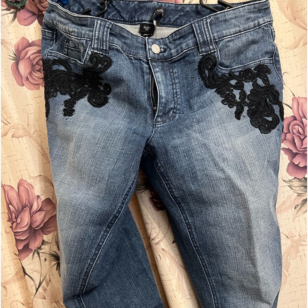 Denim jeans with black appliqué on pockets and down halfway one side